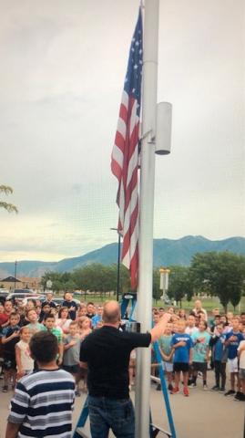The U.S. flag being raised up the flag pole.