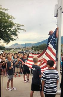 The U.S. flag being hung on the flag pole.